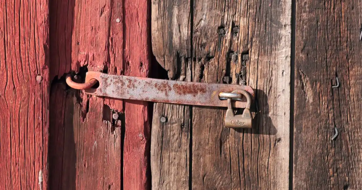 Vieux verrou rouillé sur une porte en bois, symbole des risques des codes IPTV gratuits