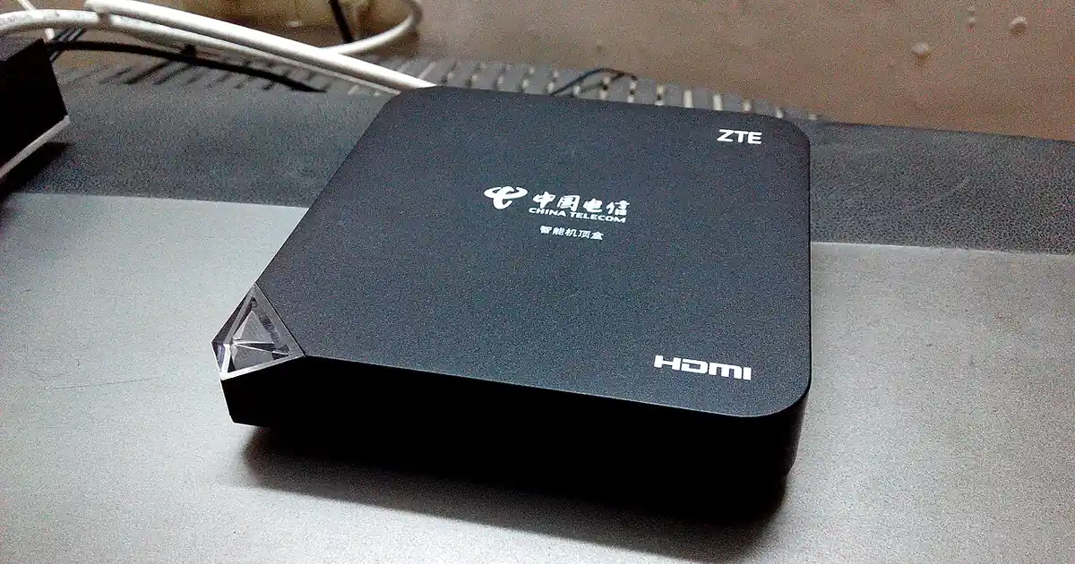Boîtier IPTV noir avec sortie HDMI, du type MAG ou Formuler, posé sous un téléviseur